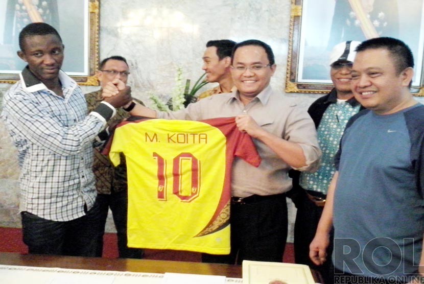  Pemain timnas Mali Morimakan Koita, berjabat tangan dengan Presiden Sriwijaya FC Dodi Reza Alex (tengah), usai menandatangani kontrak dengan Sriwijaya FC di Palembang, Jumat (5/12).