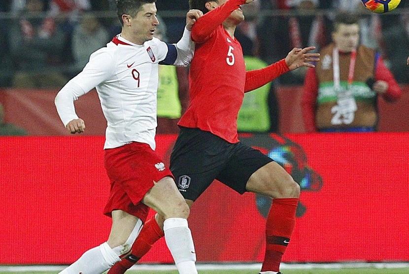  Pemain timnas Polandia Robert Lewandowski (kiri), berebut bola dengan pemain Korea Selatan Hyun-soo Jang, dalam laga persahabatan internasonal yang berlangsung di Chorzow, Polandia, Selasa (27/3) malam waktu setempat. 