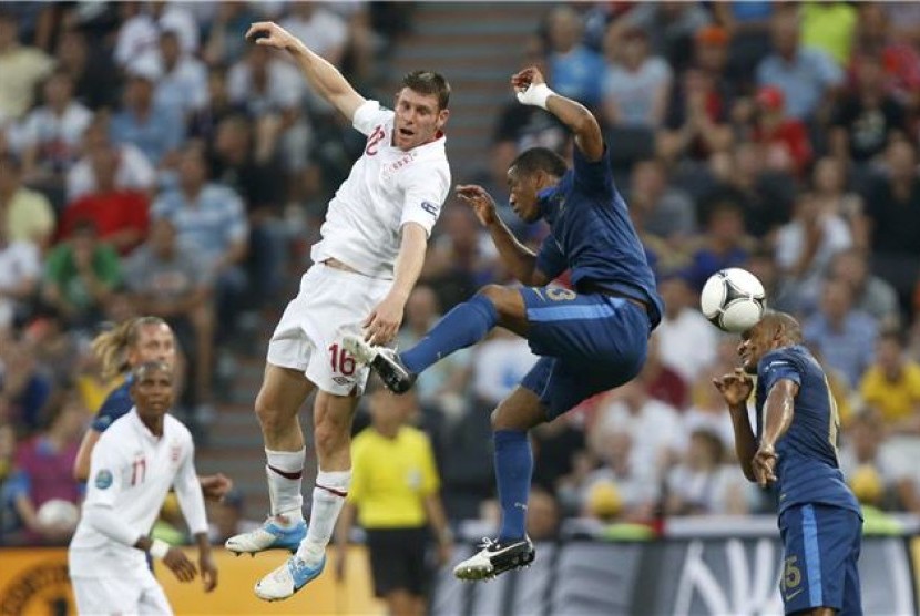 Pemain timnas Prancis, Florent Malouda (kanan) dan Patrice Evra, terlibat duel udara dengan gelandang Inggris, James Milner, di laga Grup D Piala Eropa 2012 di Donbass Arena, Donetsk, Ukraina, Senin (11/6). 