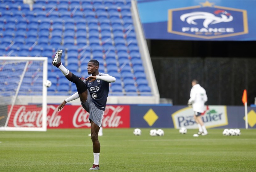 Pemain Timnas Prancis, Paul Pogba, melakukan pemanasan saat sesi latihan di Stadion Groupama, Decines, Lyon, Prancis, Jumat (8/6).