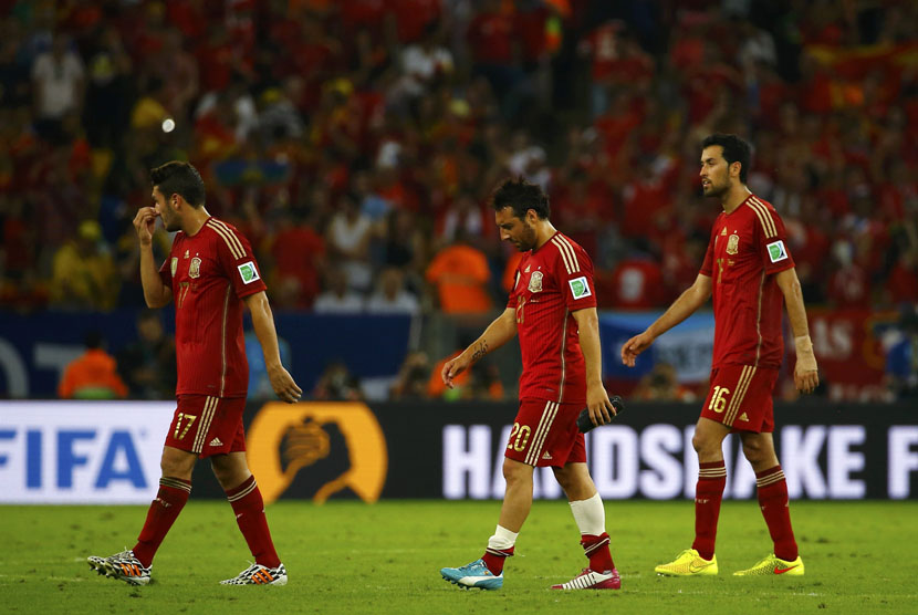 Pemain Timnas Spanyol (kiri-kanan) Koke, Santi Cazorla, dan Sergio Busquets berjalan gontai usai menelan kekalahan 0-2 dari Cile di laga kedua Grup B Piala Dunia 2014 di Stadion Maracana, Rio de Janeiro, Rabu (18/6). 