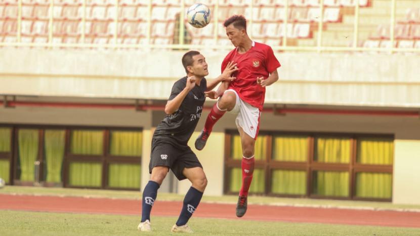 Pemain timnas U-16 (merah) berebut bola dengan pemain Bina Taruna dalam laga uji coba di Stadion Patriot Candrabagha, Bekasi, Selasa (28/7).