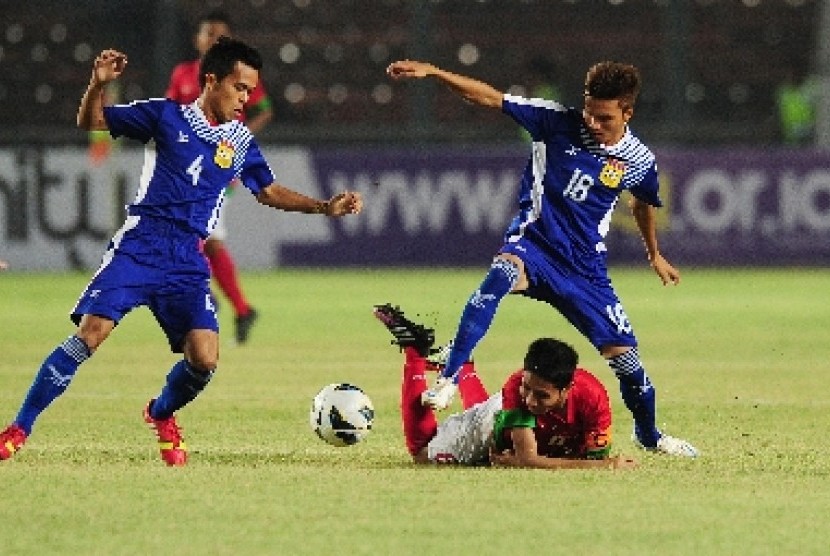 Pemain timnas U-19 Indonesia, Evan Dimas, terjatuh saat duel dengan pemain Laos di kualifikasi Piala Asia (AFC) di Stadion Gelora Bung Karno, Selasa (8/10) malam WIB.