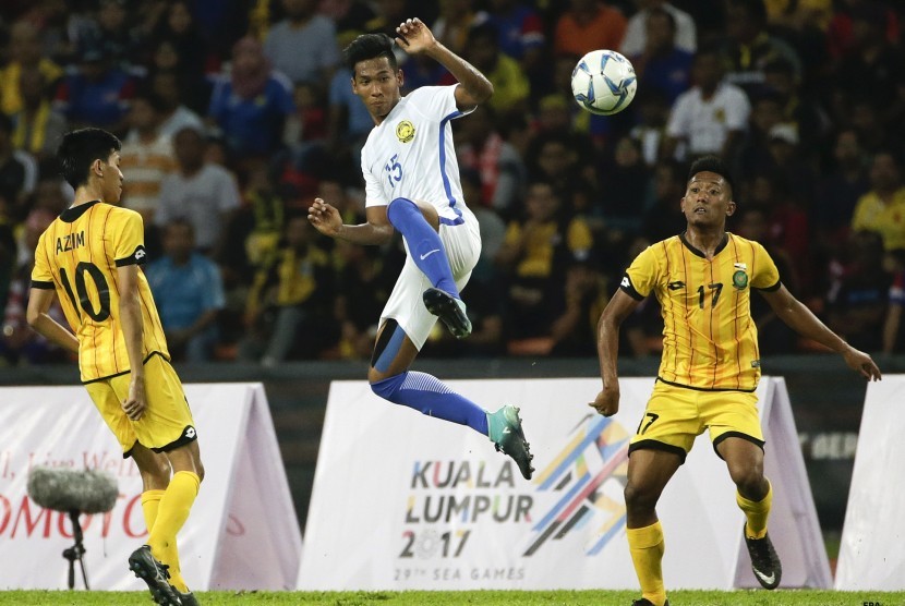 Pemain Timnas U-22 Brunei Darussallam, Mohammad Alimuddin (tengah), berupaya mengamankan bola dari kepungan pemain Malaysia dalam laga Grup A cabang olahraga sepak bola SEA Games 2017 di Stadion Shah Alam, Selangor, Malaysia, Senin (14/8). 