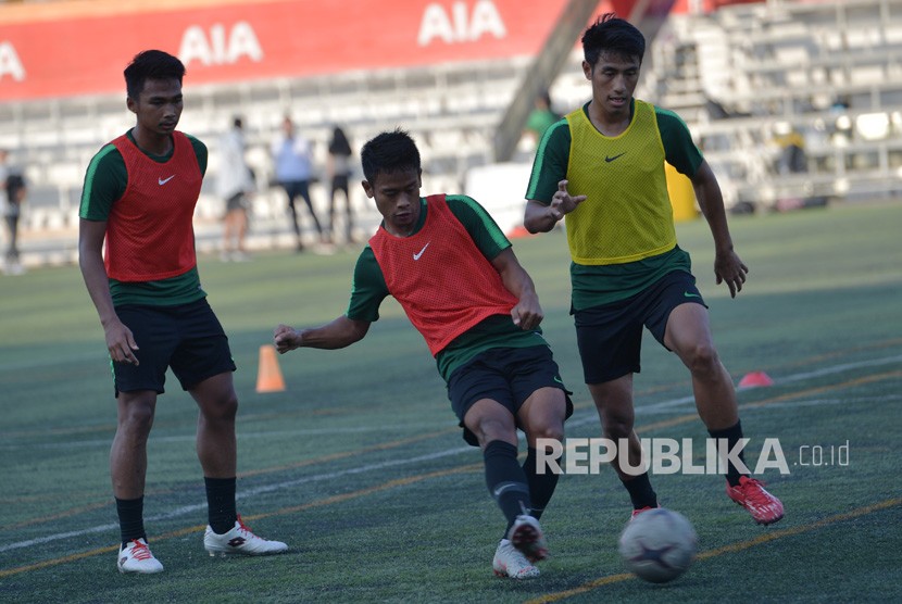 Pemain Timnas U-22 Hanif Abdurrauf Sjahbandi (kanan) berebut bola dengan rekannya Fredyan Wahyu (tengah) dalam latihan menjelang pertandingan Sepak Bola AFF U-22 di lapangan Stadion AIA - Home Of Western, Phnom Penh, Kamboja, Kamis (21/2/2019). 