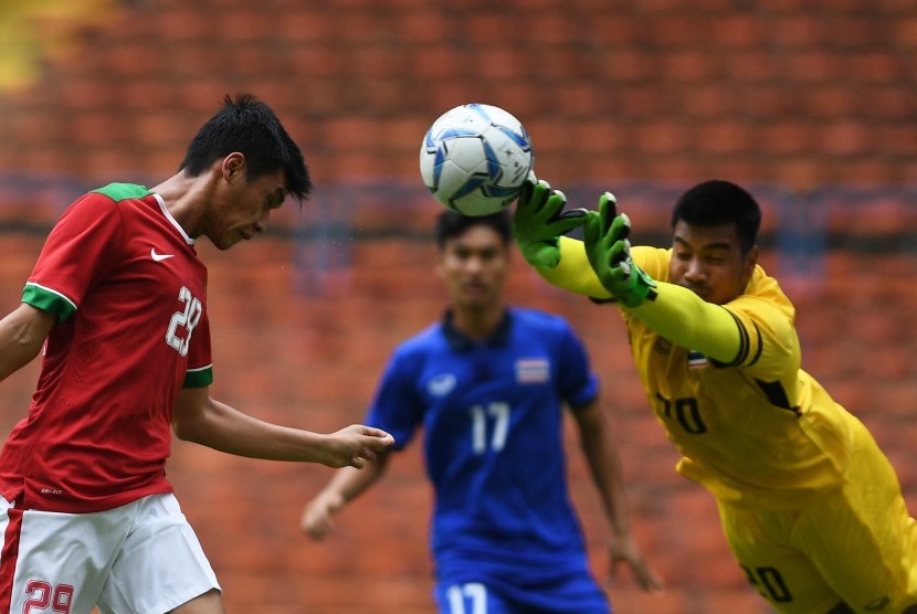 Pemain Timnas U-22 Septian David Maulana (kiri) menyundul bola ditahan kiper Timnas Thailand U-22 Nont Muangngam (kanan) dalam penyisihan grup B SEA Games XXIX Kuala Lumpur 2017 di Stadion Shah Alam, Selangor, Malaysia, Selasa (15/8). 