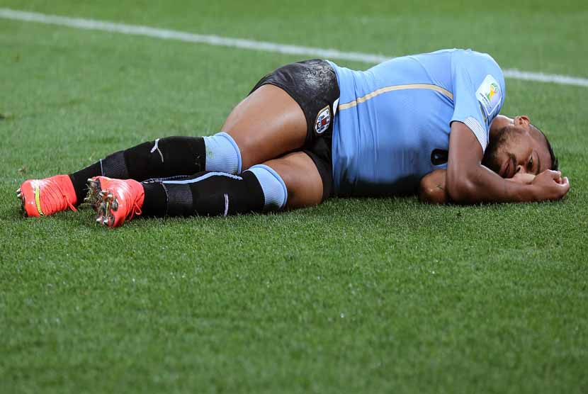 Pemain Timnas Uruguay, Alvaro Pereira, tergeletak di lapangan saat menghadapi Inggris di laga Grup D Piala Dunia 2014 Brasil di Sao Paulo, Brasil, 19 Juni 2014. 