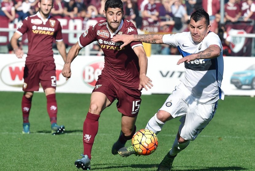 Pemain Torino Marco Benassi dan pemain Inter, Medel, saling berduel berebut bola dalam laga Serie A Italia antara torino dan Inter Milan di Stadion Olimpico, Ahad (8/11)