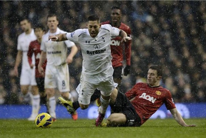 Pemain Tottenham Hotspur, Clint Dempsey (tengah), terlibat duel dengan pemain Manchester United, Michael Carrick, pada laga Liga Primer Inggris di White Hart Lane, London, akhir Januari lalu.  