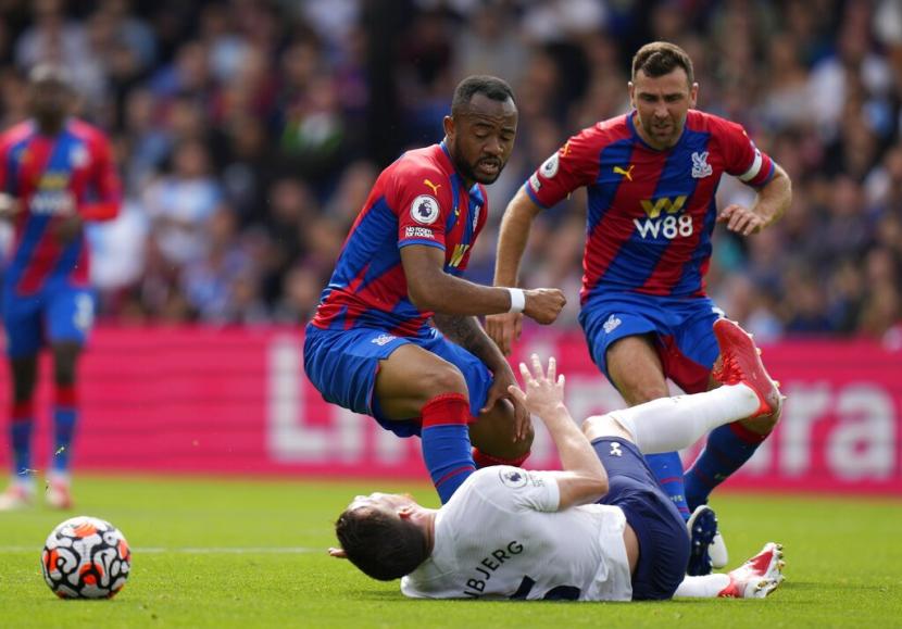 Pemain Tottenham Hotspur Pierre-Emile Hojbjerg terjatuh saat berduel bola dengan pemain Crystal Palace Jordan Ayew (kiri).