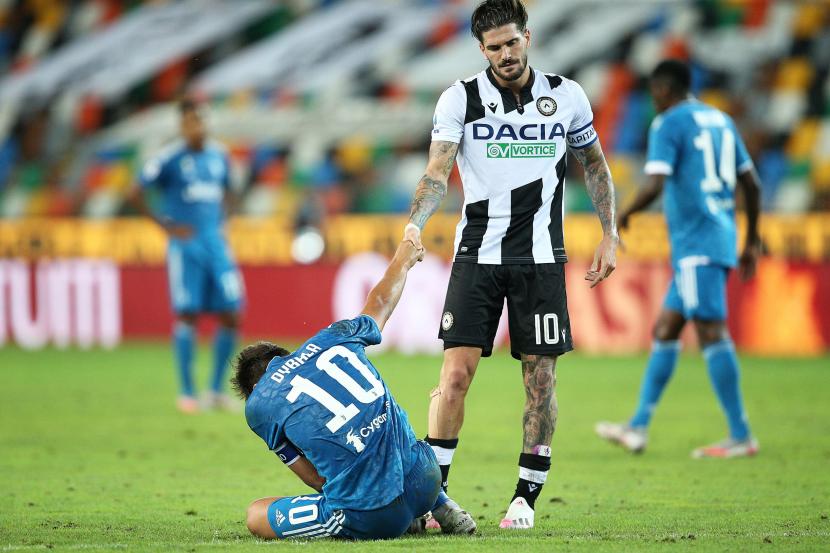  Pemain Udinese Rodrigo De Paul berusaha menolong striker Juventus Paulo Dybala yang cedera ketika kedua tim bertemu pada lanjutan Serie A Liga Italia, Jumat (24/7).
