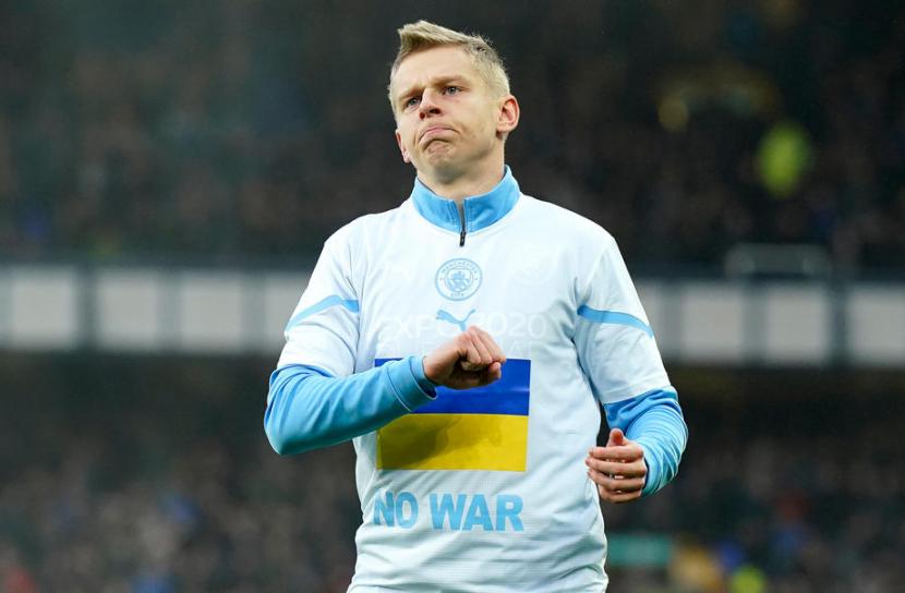 Pemain Ukraina yang membela Manchester City Oleksandr Zinchenko mengenakan kaus dengan pesan jangan ada perang.