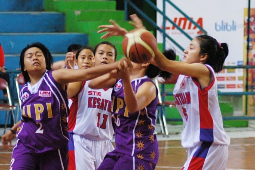 Pemain Universitas Pendidikan Indonesia (UPI), Nurfitriana berusaha merebut bola dari tangan pemain STIE Kesatuan pada pertandiangan bola basket Liga Mahasiswa (Lima) di Gor Padjajaran, Bandung, Ahad (2/12)