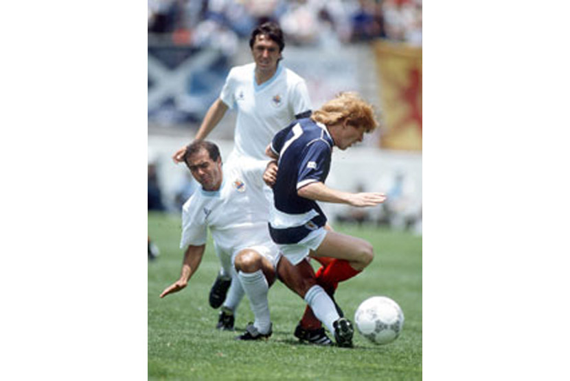 Pemain Uruguay, Jose Batista (kiri), menjegal pemain Skotlandia, Gordon Strachan, dalam laga Piala Dunia 1986.
