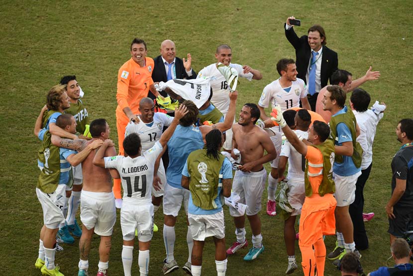 Pemain Uruguay merayakan setelah memenangkan 2014 grup Piala Dunia FIFA D pertandingan babak penyisihan antara Italia dan Uruguay di Estadio Arena das Dunas di Natal, Selasa (24/6). (EPA/Vassil Donev).