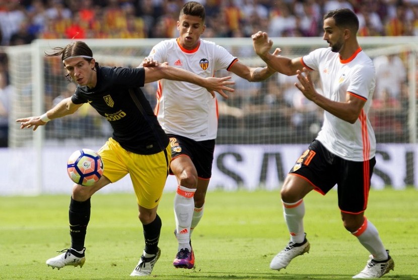 Pemain Valencia, Joao Cancelo dan Martin Montoya berebut bola dengan penggawa Atletico Madrid, Filipe Luis. Atletico Madrid sukses mengalahkan Valencia dengan skor 2-0, Ahad (2/10).