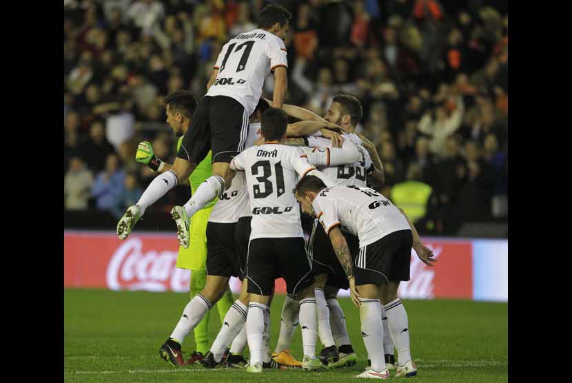 Pemain Valencia merayakan keberhasilan mereka mengalahkan Real Madrid dalam laga La Liga Spanyol di Stadion Mestalla, Valencia, Ahad (4/1).