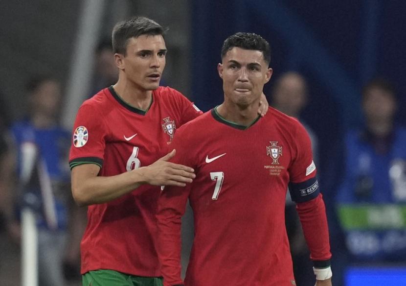 Pemain veteran Portugal Cristiano Ronaldo (kanan) dihibur rekannya Joao Palhinha setelah gagal menjebol gawang Slovenia pada 16 besar Euro 2024.