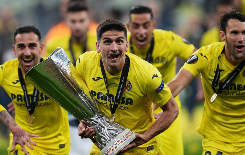Pemain Villarreal Gerard Moreno mengangkat trofi Liga Europa 2020/2021 setelah mengalahkan Manchester United lewat adu penalti. 