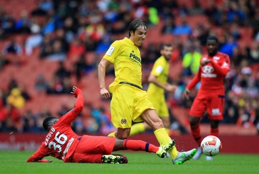 Pemain Villarreal Tomas Vina yang membawa bola coba diadang pemain Olympique Lyon dalam laga Emirates Cup, Ahad (26/7).