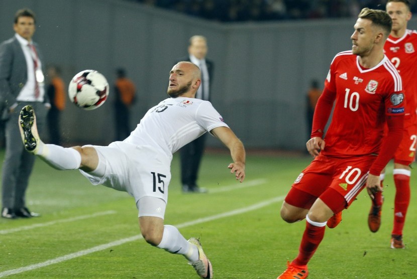 Pemain Wales Aaron Ramsey (kanan) ketika beraksi dengan pemain Georgia Valerian Gvilia (kiri) pada laga kualifikasi Grup D Piala Dunia 2018 Zona Eropa di Boris Paichadze Dinamo Arena in Tbilisi, Georgia, Sabtu (7/10) dini hari WIB. 