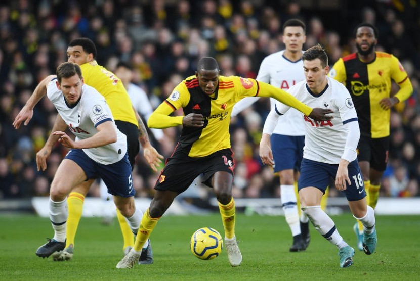 Pemain Watford Abdoulaye Doucoure (tengah) dijaga dua pemain Tottenham Hotspur dalam pertandingan Liga Inggris, Sabtu (18/1).