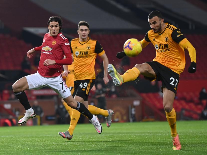 Pemain Wolves Romain Saiss (kanan) dan penyerang Manchester United Edinson Cavani (kiri)