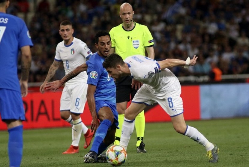 Pemain Yunani Carlos Zeca (kiri) berebut bola dengan pemain Italia Jorginho dalam pertandingan kualifikasi Piala Eropa 2020 Grup J, Ahad (9/6) dini hari WIB