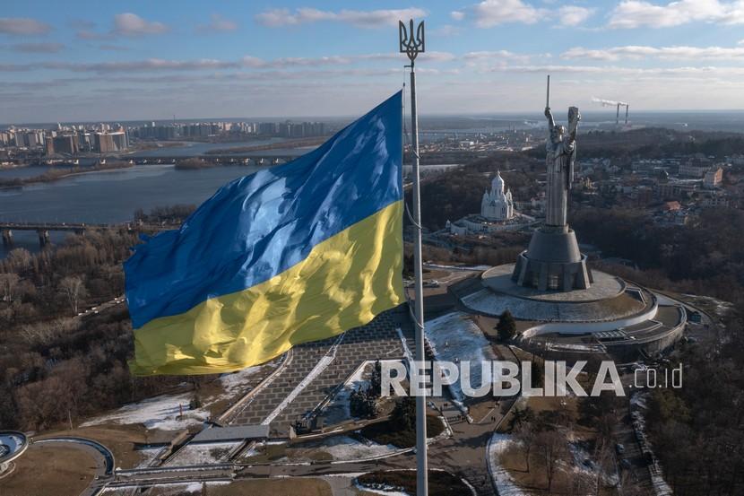  Pemandangan bendera nasional Ukraina melambai di atas ibu kota dengan Monumen Tanah Air di sebelah kanan, di Kyiv Minggu, 13 Februari 2022. Beberapa maskapai telah menghentikan atau mengalihkan penerbangan ke Ukraina di tengah meningkatnya kekhawatiran bahwa invasi oleh Rusia akan segera terjadi meskipun akhir pekan yang intensif pembicaraan antara Kremlin dan Barat.