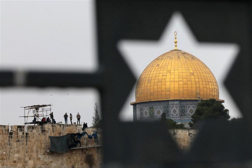  Pemandangan dari Bukit Zaitun menunjukkan orang-orang Palestina berdiri di tembok Kota Tua di kompleks Temple Mount di Kota Tua Yerusalem pada 06 Januari 2023. Hikmah Perjalanan Isra' Mi'raj Nabi Muhammad SAW