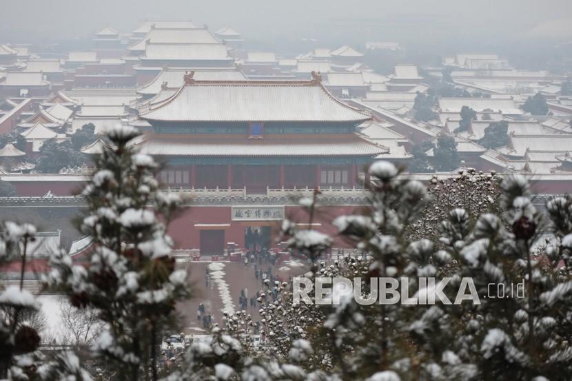 Pemandangan Istana Kota Terlarang yang bersalju dari puncak perbukitan Jingshan, Beijing, China, Sabtu (22/1/2022). Beijing diguyur hujan salju dalam tiga hari berturut-turut yang merupakan hujan salju pertama pada tahun 2022. 