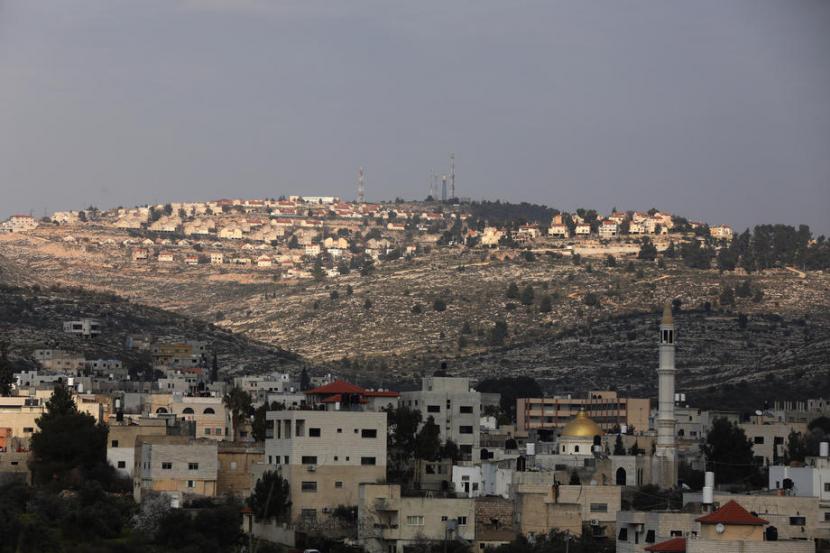 Pemandangan permukiman Israel Elon Moreh (belakang) dilihat dari Azmout, sebuah desa di Palestina dekat Tepi Barat. Aktivitas pembangunan permukiman Israel di Tepi Barat melonjak pada tahun 2019. Ilustrasi.