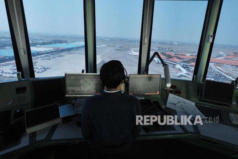 Pemandu lalu lintas udara AirNav Indonesia memantau pergerakan lalu lintas udara pesawat melalui layar radar di menara kontrol (Air Traffic Controller/ATC) Bandara Internasional Soekarno-Hatta, Tangerang, Banten.