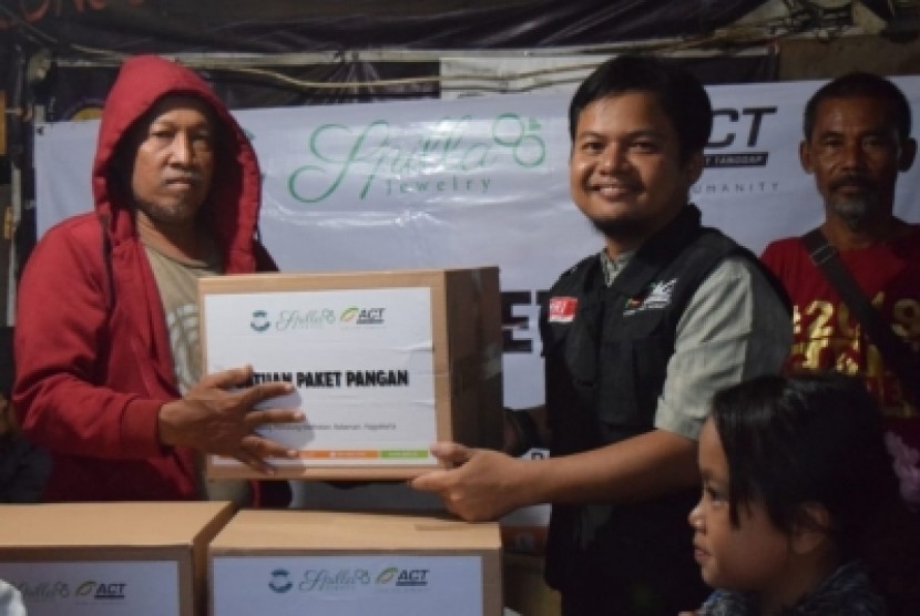 Pembagian bantuan paket pangan kepada masyarakat Kampung Pemulung  oleh ACT DIY di Kabupaten Sleman, Senin (4/3). 
