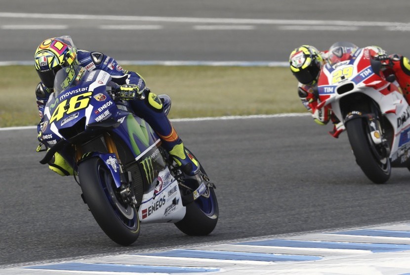 Pembalap asal Italia Valentino Rossi (kiri) dari Movistar Yamaha dan Andrea Iannone (kanan) sedang pemanasan di Jerez Circuit sebelum dimulainya balapan MotoGP di Jerez, Ahad (24/4).