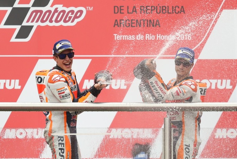 Pembalap dari Honda, Marc Marquez (kiri), merayakan kemenangannya bersama Dani Pedroza (kanan) di podium MotoGP Argentina