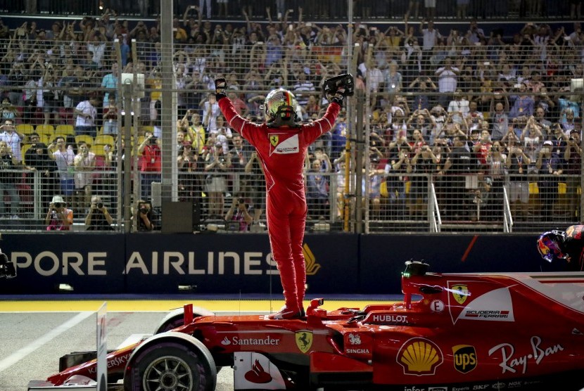 Pembalap Ferrari, Sebastian Vettel memberikan salam kepada penonton GP Singapura setelah berhasil meraih posisi start terdepan pada babak kualifikasi, Sabtu (16/9).