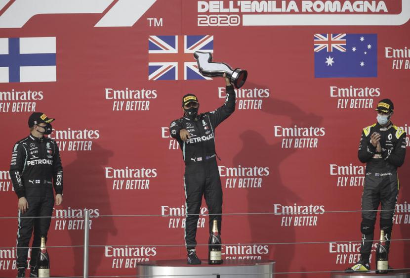 Pembalap Formula Satu (F1) dari tim Mercedes, Lewis Hamilton (tengah) merayakan gelar juara balap GP Emilia Romagna di Sirkuit Imola, Italia, Ahad (1/11).