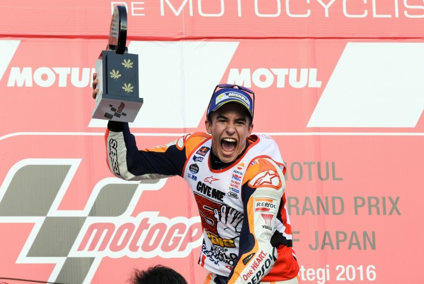 Pembalap Honda, Marc Marquez merayakan kemenangan di podium sirkuit Motegi, Jepang, Ahad (16/10). Kemenangan membuat Marquez menjadi juara dunia MotoGP 2016.
