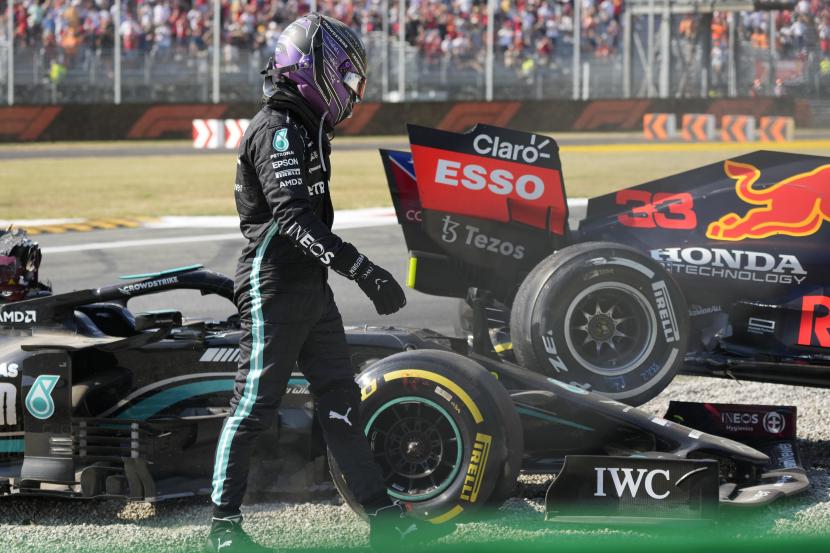Pembalap Mercedes Lewis Hamilton dari Inggris berjalan pergi setelah menabrak pembalap Red Bull Max Verstappen dari Belanda selama Grand Prix Formula Satu Italia, di arena pacuan kuda Monza, di Monza, Italia, Minggu, 12 September 2021.