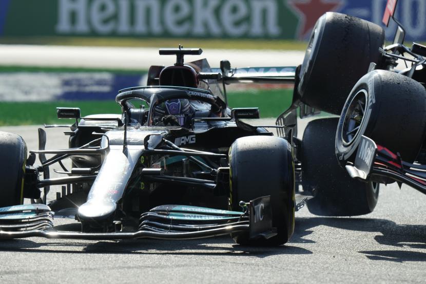 Pembalap Mercedes Lewis Hamilton dari Inggris bertabrakan dengan pebalap Red Bull Max Verstappen dari Belanda selama Grand Prix Formula Satu Italia, di arena pacuan kuda Monza, di Monza, Italia, Ahad (12/9).
