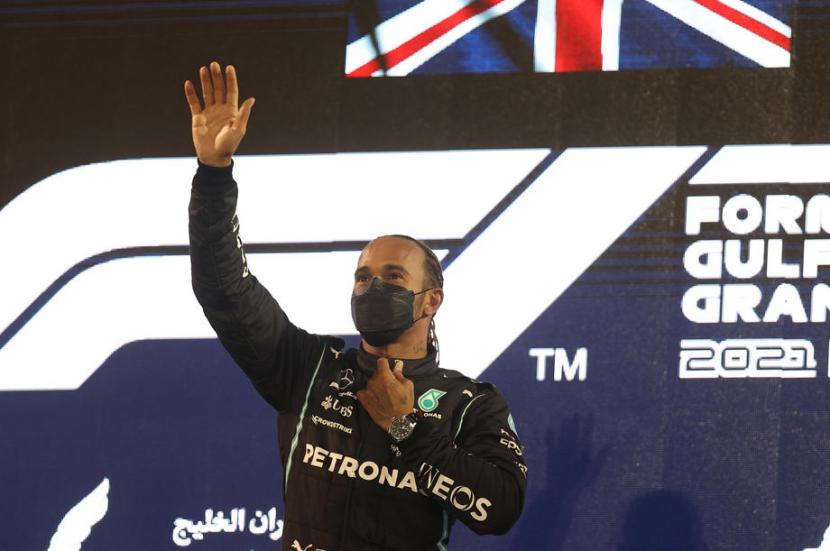 Pembalap Mercedes Lewis Hamilton mengangkat tangan di podium juara GP Bahrain. 