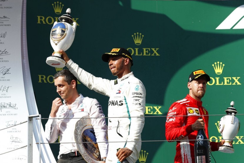 Pembalap Mercedes, Lewis Hamilton (tengah) menjadi juara GP Hungaria, di Sirkuit Hungaroring, Ahad (29/7).