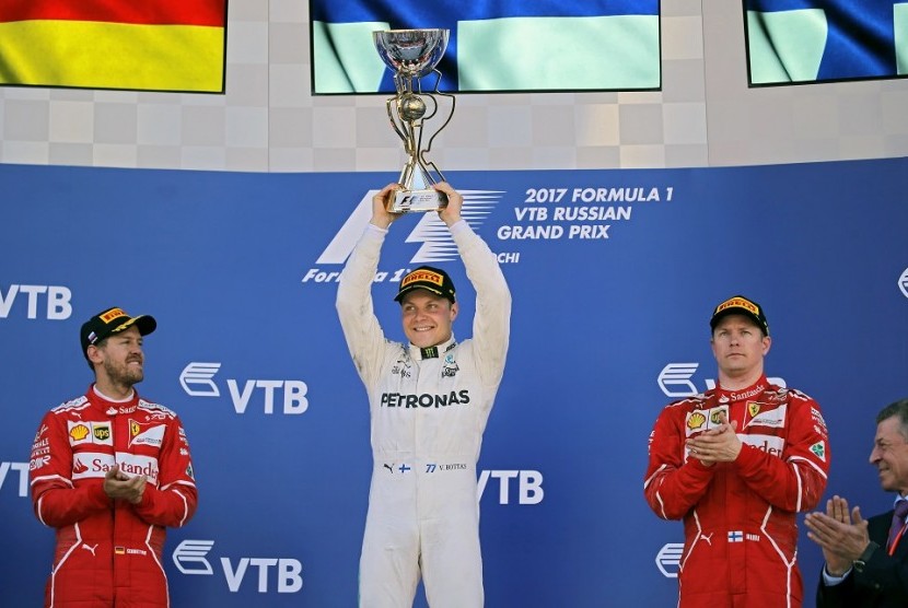 Pembalap Mercedes Valtteri Bottas (tengah) merayakan keberhasilannya menjuarai GP F1 Rusia, Ahad (30/4).