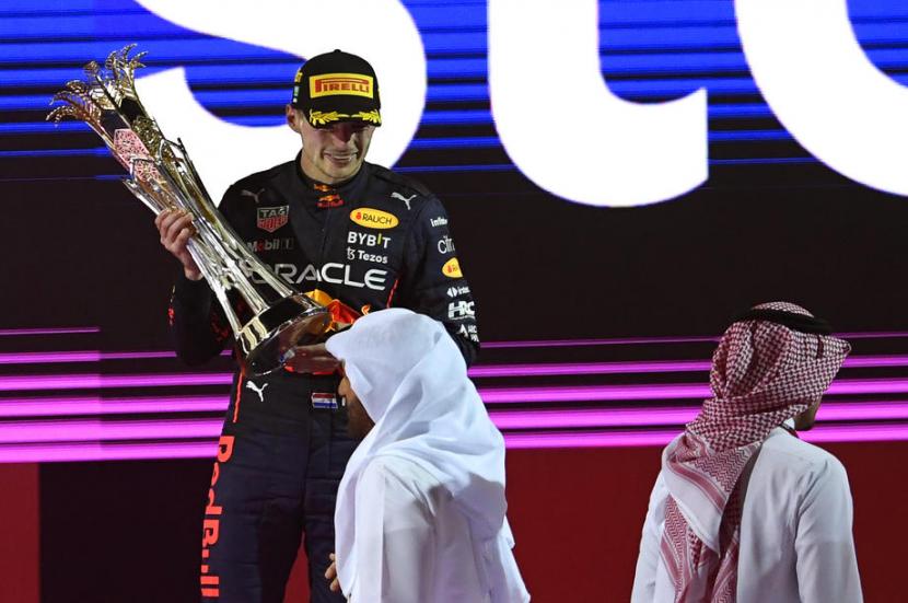 Pembalap Red Bull Max Verstappen menerima piala juara GP F1 Arab Saudi.