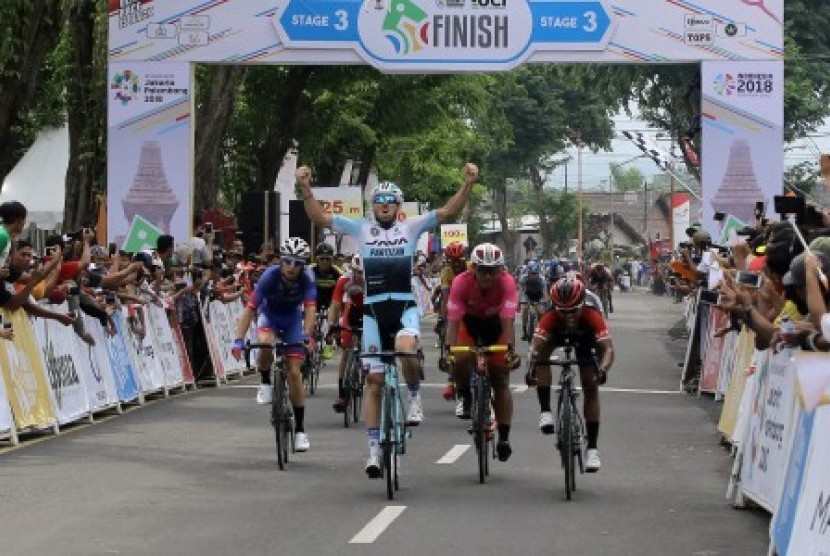 Pembalap sepeda asal Yunani Charalampos Kastrantas (kiri) dari tim Java Partizan Pro Cycling Team melakukan selebrasi setelah melewati garis finis di Taman Blambangan, Banyuwangi, Jawa Timur, Sabtu (27/1). Etape ke-3 Tour de Indonesia tersebut, start dari Probolinggo melalui Lumajang, Jember dan finis di Banyuwangi dengan jarak 200 kilometer. 
