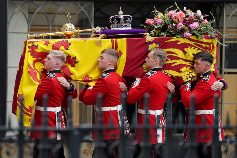 Pembawa jenazah membawa peti mati Ratu Elizabeth II dalam prosesi pemakaman kenegaraan di Westminster Abbey di London, Senin, 19 September 2022. Selama pemerintahan Ratu Elizabeth II, hasil investigasi soal UFO dan alien yang digagas sang suami, Pangeran Philip, tidak pernah dipublikasikan.