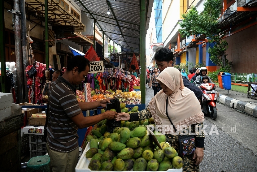 Pembeli melihat barang yang dijual pedagang kaki lima (PKL) di Pasar Balimester, Jatinegara, Selasa (23/11).