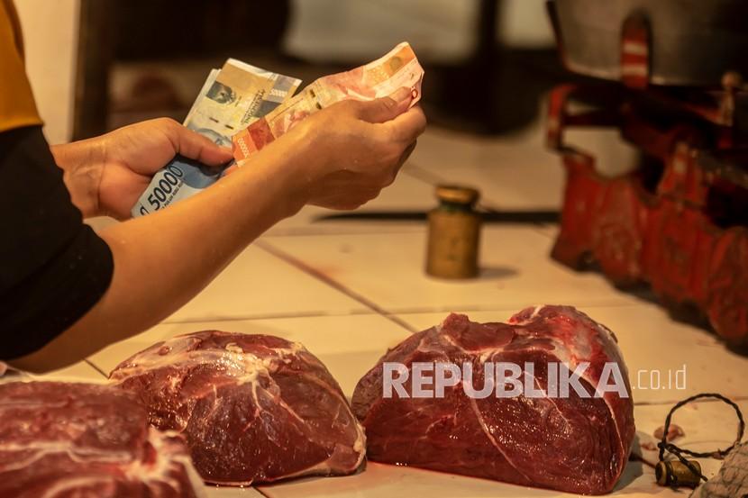 Pembeli membayar daging sapi kepada penjual, di saat harga daging yang mahal. (Ilustrasi) 