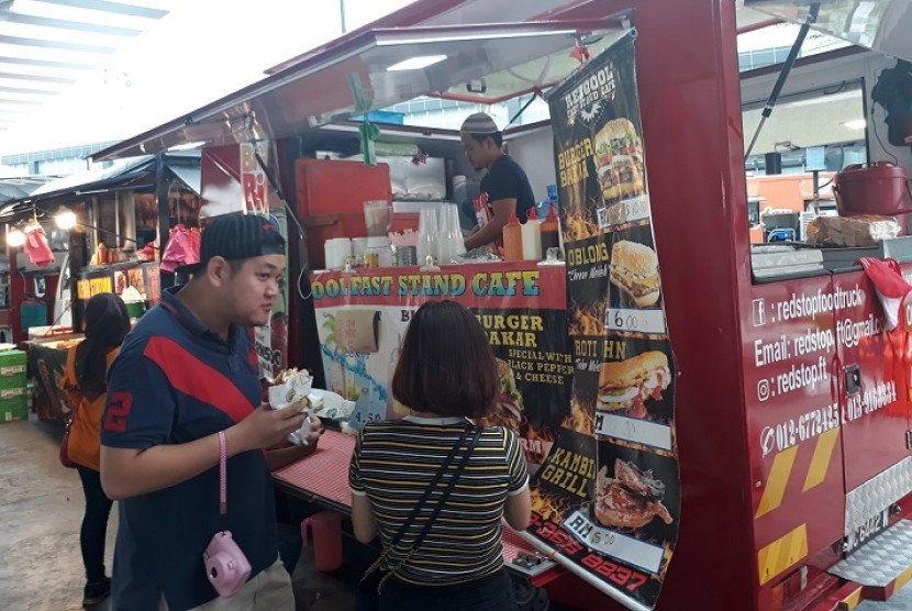 Pembeli membeli makanan di food truck Kompleks Olahraga Bukit Jalil, Selangor, Senin (21/8).